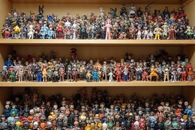 Display shelf filled with various anime figurines, showcasing different sizes and types like scale figures, Nendoroids, and Figmas.
